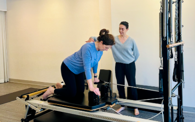 Lisa works with a practitioner at DBP to improve back pain with personalized Pilates